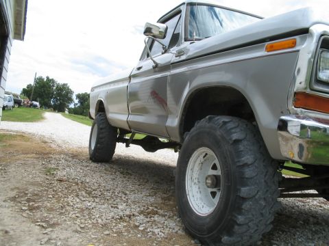 1979 Ford F-150 - A lifted 1979 Ford F-150 sits on a gravel driveway with other vehicles in the background.