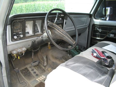 1979 Ford F-150 - Interior view of a 1979 Ford F-150, the dashboard, steering wheel, and floor mats.