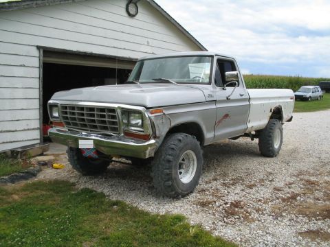 1979 Ford F-150 - A silver 1979 Ford F-150 pickup truck is parked on a gravel driveway next to a white garage, with another vehicle visible in the background.