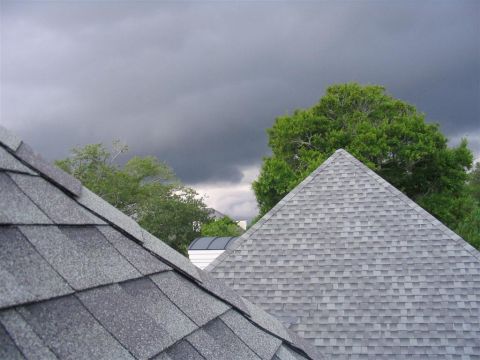 2000 Honda Accord - The image shows two residential roofs against a backdrop of dark, ominous clouds and lush green trees.