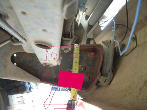 1994 Ford Bronco - A tape measure is used to measure a component attached to the vehicle's frame.