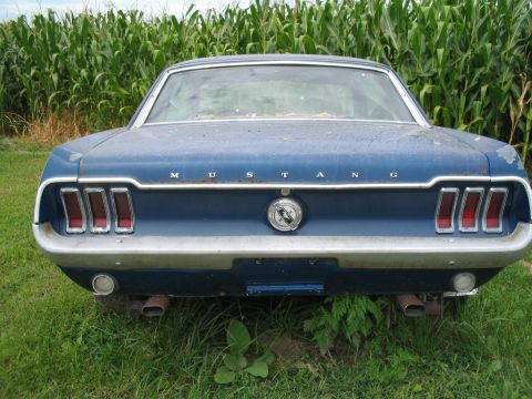 1967 Ford Mustang - Rear view of a blue 1967 Ford Mustang, showing its distinctive triple taillights and 'Mustang' badging.