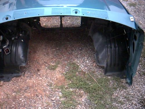 Vehicle front clip, teal color, showing inner fender wells and grille area