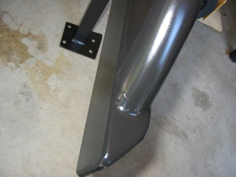 1995 Ford Bronco - A close-up view of a vehicle's rock slider, showing its mounting bracket and metallic finish.