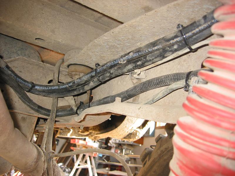 Frame-rail underbody with new Gates 3/8 fuel line and wire loom beside red coil spring