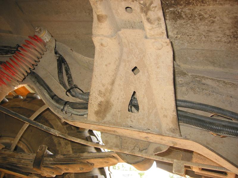 Underbody crossmember with fuel line and loom, red coil spring and leaf spring visible