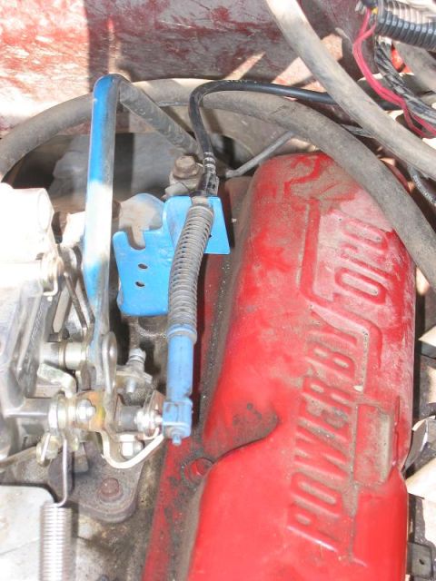 1985 Ford Bronco - Engine component detail showing 'POWER BY FORD' marking and blue linkage assembly.