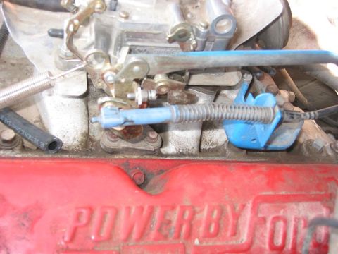 1985 Ford Bronco - A close-up view of a vehicle's carburetor and engine block.