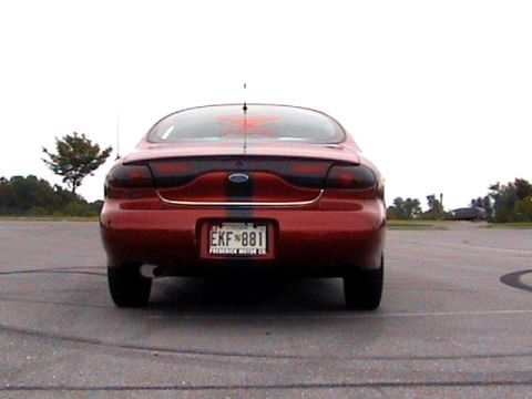 1996 Ford Taurus - Rear view of a red 1996 Ford Taurus sedan parked on asphalt.