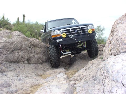 1993 Ford Bronco - This 1993 Ford Bronco is shown tackling a challenging rocky path in a desert environment.