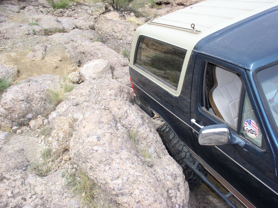 Ford Bronco navigating rocky terrain, driver's side visible