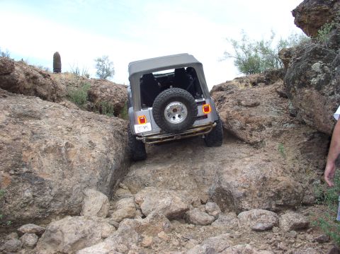 1993 Ford Bronco - A gray Jeep Wrangler TJ navigates a challenging rocky terrain.