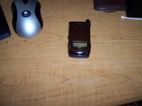 1990 Ford Bronco - A flip phone and a computer mouse are placed on a wooden surface.