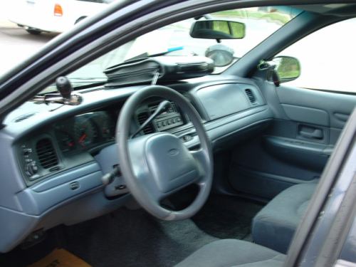 Gray cloth interior of Ford sedan, steering wheel, dash and shifter on column