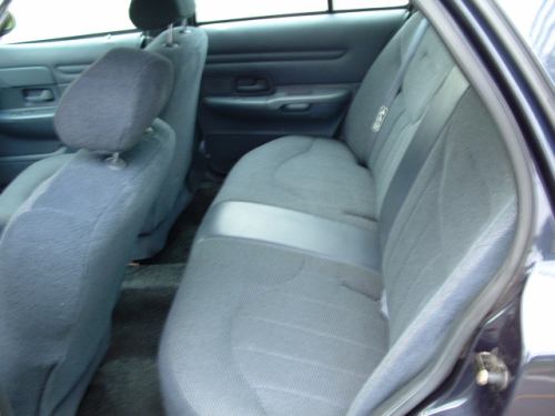 Gray cloth rear bench seat of a sedan with center armrest area and door panel