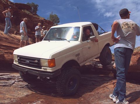 1987 Ford Bronco - This 1987 Ford Bronco tackles a challenging off-road course with onlookers observing the action.