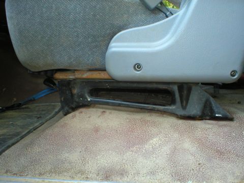 1986 Ford Bronco - Close-up of a vehicle's seat mounting bracket, showing its construction and condition.