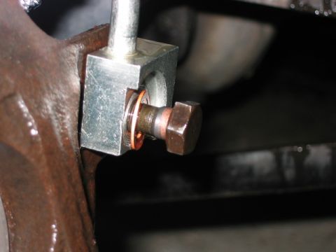 1992 Ford Bronco - A close-up view of a bolt and bracket assembly, copper washers, likely part of a vehicle's mechanical system.
