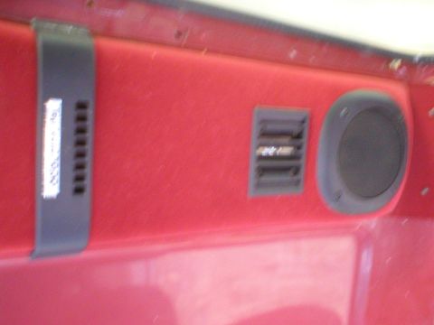 1986 Ford Bronco - Close-up of a red vehicle interior panel showing a speaker and air vent.