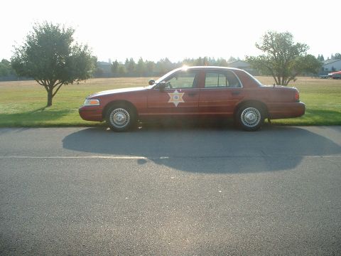 1999 Ford Crown Victoria - This 1999 Ford Crown Victoria, seen from the side, features a sheriff's star emblem on its door.
