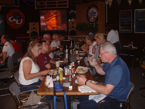 1999 Ford Crown Victoria - Diner patrons enjoy a meal while a television displays a close-up of a man's face.