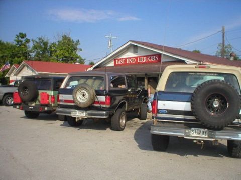 1994 Ford Bronco - Three SUVs are parked in front of a building with a sign that reads East End Liquors.