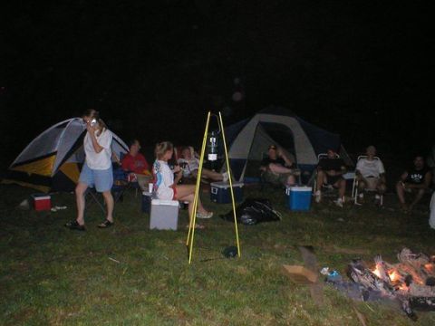 1994 Ford Bronco - A group of people are gathered around tents and a campfire during a nighttime camping trip.