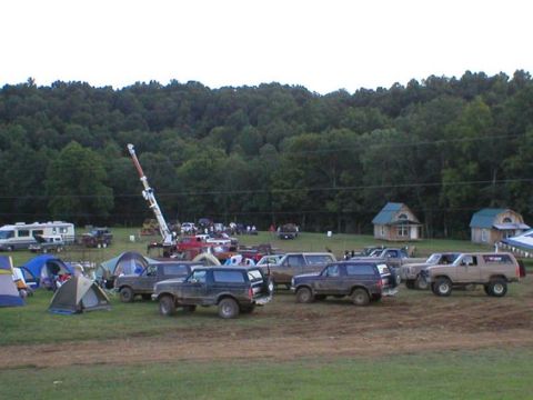1994 Ford Bronco - Multiple Ford Bronco SUVs are parked at an outdoor event with tents and a crane visible.