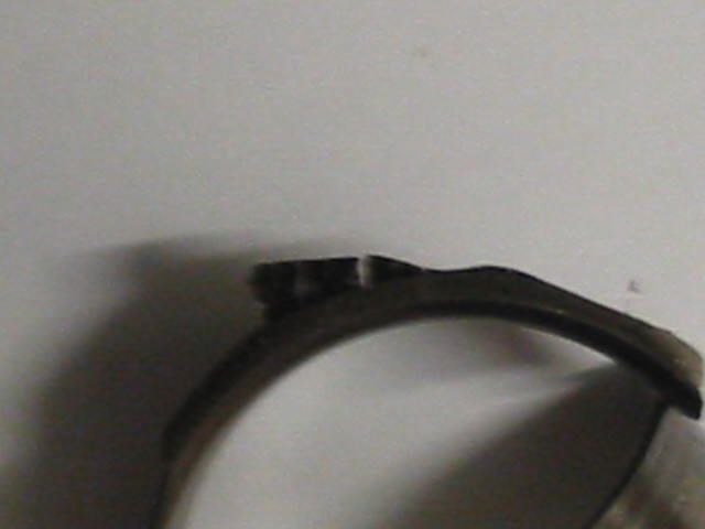 Blurry close-up of a black metal automotive part on a white background