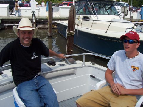 1994 Ford Bronco - Two young men enjoy a day on the water, with a larger vessel docked nearby.