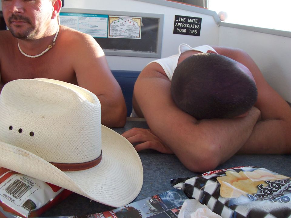 People resting on a boat with a cowboy hat and chips