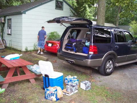 1994 Ford Bronco - Two vehicles are parked in a yard with a house and picnic table nearby.