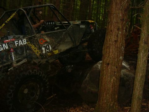 1990 Ford Bronco - This heavily modified off-road buggy navigates a rocky trail through a dense forest.