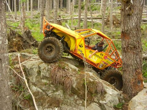 1990 Ford Bronco - This custom-built buggy navigates a challenging rocky terrain in a wooded area.