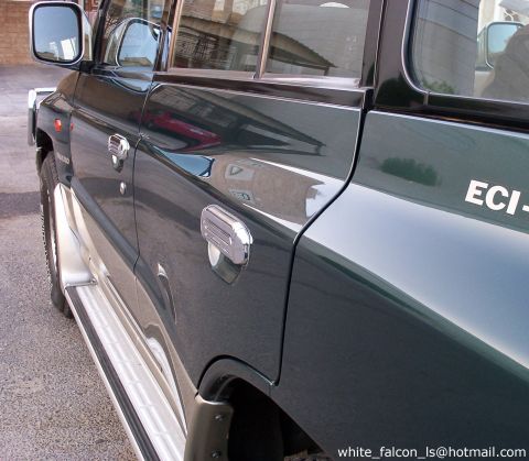 2000 Mitsubishi Montero - Dark green SUV with chrome accents and side steps, viewed from the front quarter angle.