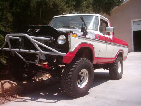 1978 Ford Bronco - This modified 1978 Ford Bronco is parked in front of a garage with its hood up.