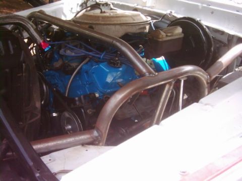 1978 Ford Bronco - Close-up view of a vehicle's engine bay, a blue engine block and custom roll cage tubing.