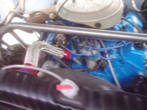 1978 Ford Bronco - Close-up view of a vehicle's engine bay, a blue engine block and custom roll cage.