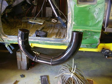 1990 Ford Bronco - A custom exhaust pipe is being fitted inside a vehicle undergoing modifications.