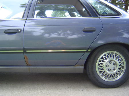 1991 Ford Taurus - A good shot of the ONLY rust spots on my car. If you look closely you can see me takin the picture. haha