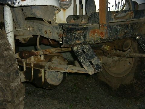 1990 Ford Bronco - The underside of a vehicle shows its suspension components and frame, with a partial license plate visible.