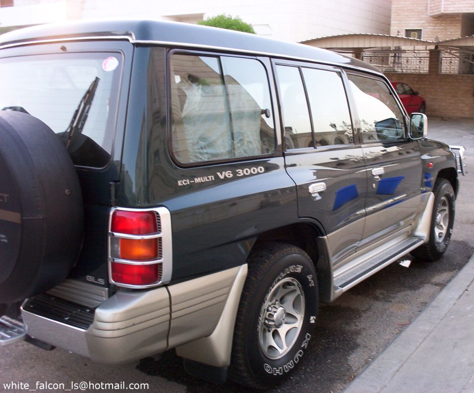 Dark green two-tone Mitsubishi Montero rear three-quarter with spare on tailgate