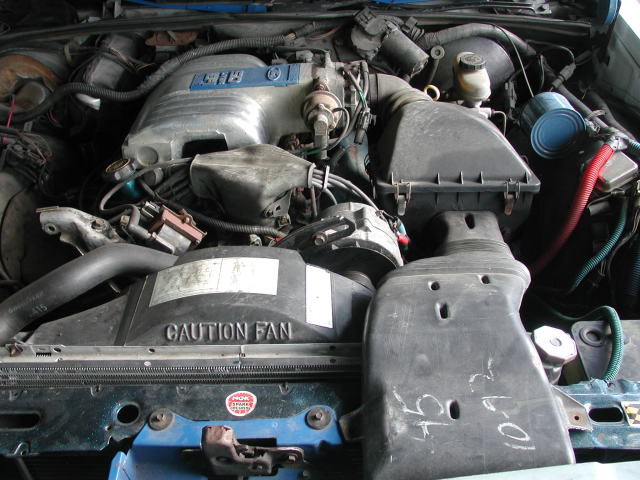 1988 Ford Crown Victoria engine bay with a V8 engine, air intake, and "CAUTION FAN" label