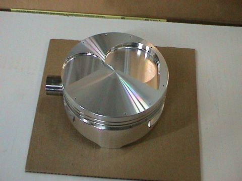 1979 Ford Bronco - A close-up view of a polished aluminum piston, likely for an engine build, is shown on a cardboard surface.