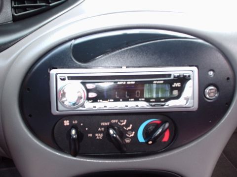 1998 Ford Taurus - Close-up of a car's center console an aftermarket JVC stereo and manual climate controls.