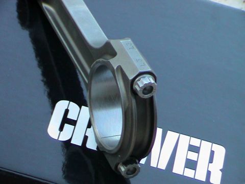 1979 Ford Bronco - A single engine connecting rod is shown, with visible markings and bolts, against a dark background.