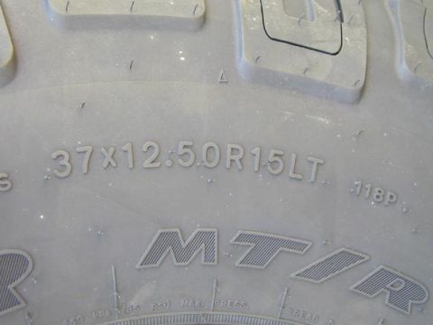 1979 Ford Bronco - Close-up of a tire showing its size and brand markings.