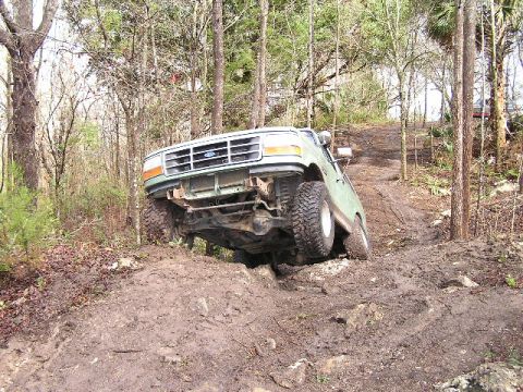 1994 Ford Bronco - This 1994 Ford Bronco tackles a challenging muddy incline, its off-road capabilities.