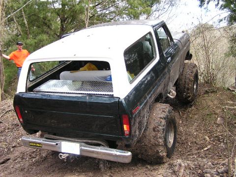 1994 Ford Bronco - This lifted 1978 Ford Bronco navigates a muddy, wooded trail, its off-road capabilities.