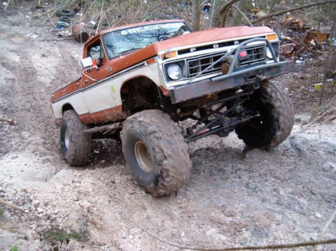 1994 Ford Bronco - This lifted Ford F-Series truck navigates a challenging off-road course in the mud.